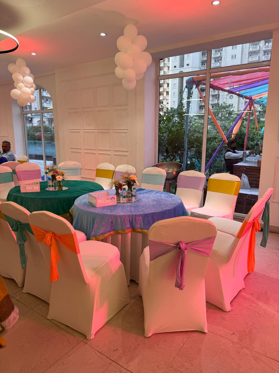 Round banquet tables with coordinated linens and chair sashes in Greater Noida