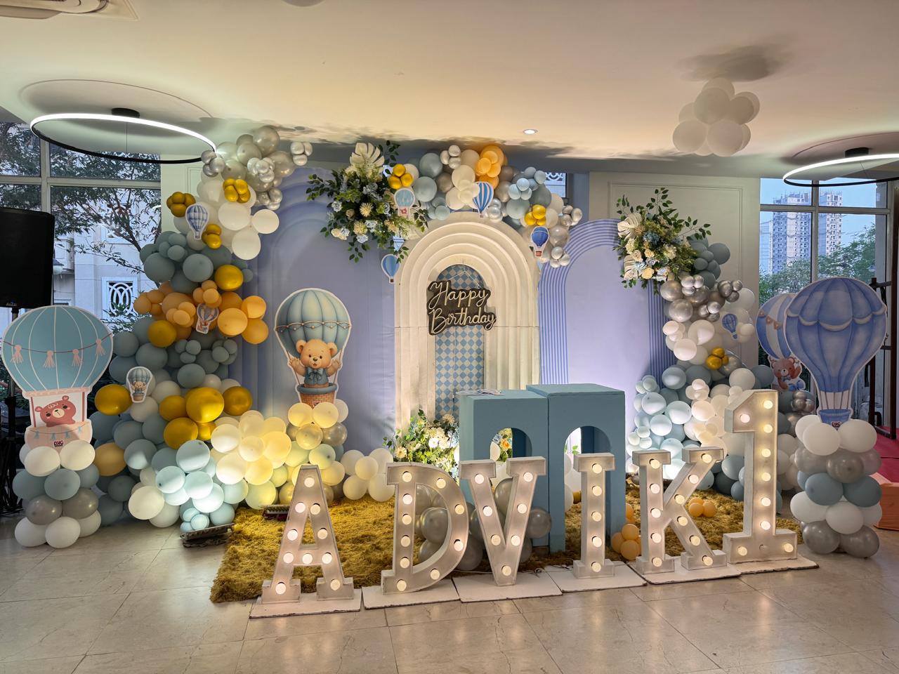 Whimsical first birthday stage with marquee letters and balloon decor in Greater Noida